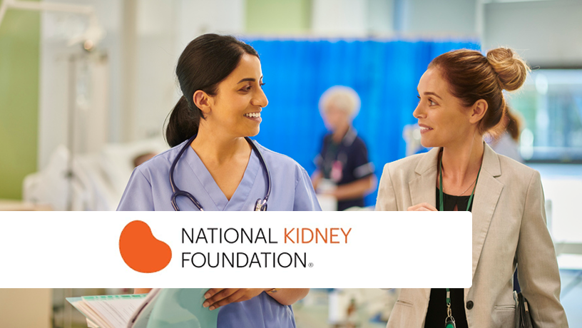 Two smiling women in a medical setting, one in blue scrubs with a stethoscope and the other in a blazer with a green lanyard, conversing in front of blurred hospital curtains. The National Kidney Foundation logo with an orange kidney shape is overlaid in the bottom left.